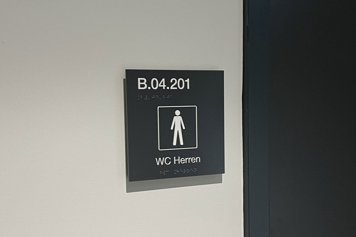 Festbetextetes Türschild mit der Raumnummer B.04.201, Brailleschrift, Piktogramm und der Beschriftung WC Herren