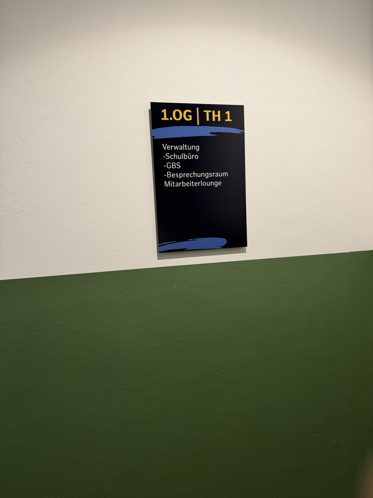 Wegweiser 1.OG | TH 1 mit den Zielen Verwaltung, Schulbüro, GBS, Besprechungsraum und Mitarbeiterlounge