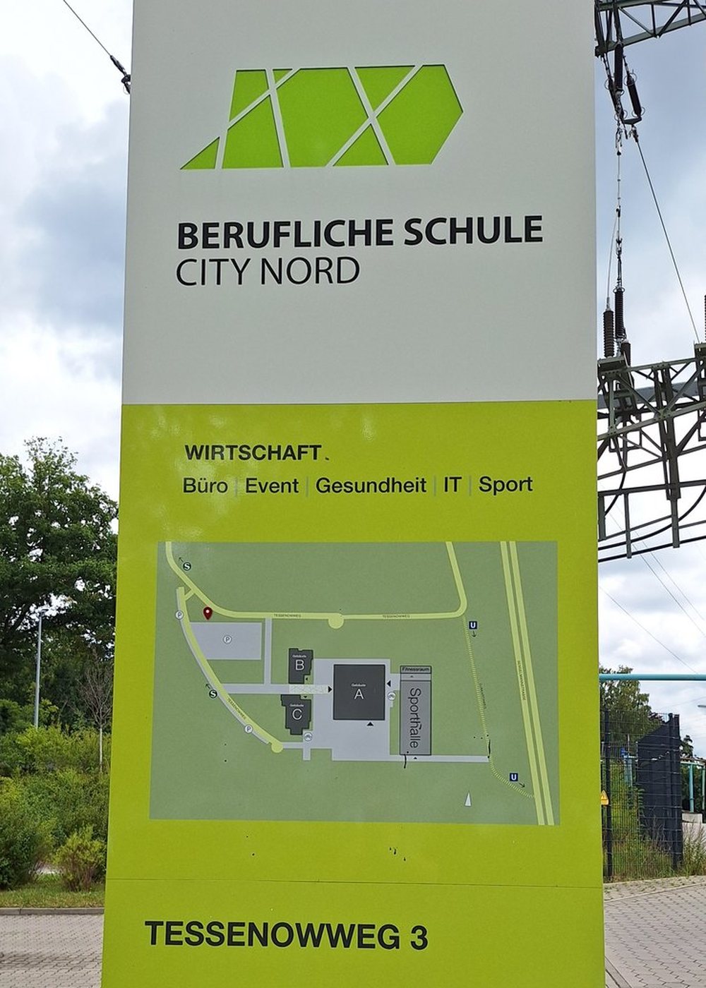 Monolith der Beruflichen Schule City Nord: oben Logo und Schulname, darunter die Zeile Wirtschaft mit Büro, Event, Gesundheit, IT und Sport, ein Lageplan des Campus und unten die Adresse Tessenowweg 3.