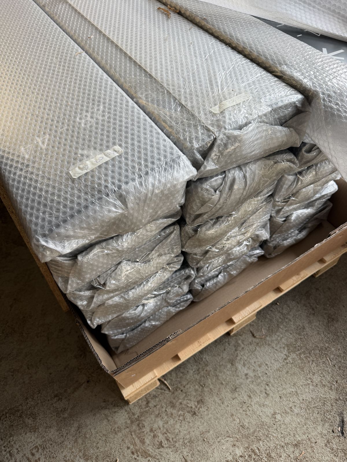 Verpackte, flache Elemente auf einer Holzpalette